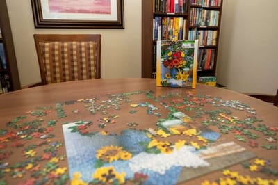 Puzzle pieces scattered on a table in a cozy room