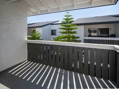 View from a balcony overlooking greenery and buildings.