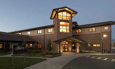 Exterior view of Heather Gardens facility at dusk