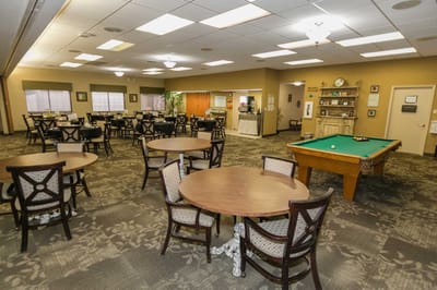 Common area with tables, chairs, and a pool table