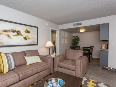 Cozy living room with brown sofas and a dining area