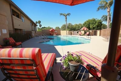 Outdoor pool area with lounge chairs and umbrellas