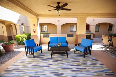 Outdoor sitting area with blue chairs and a table
