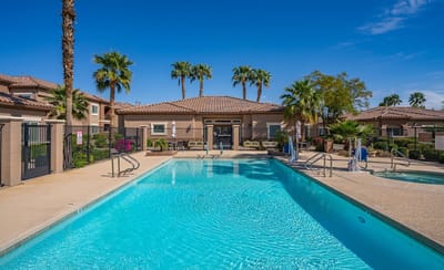 Outdoor pool area with palm trees and seating