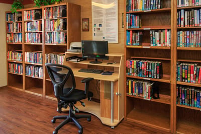 Interior view of a library with bookshelves and a desk