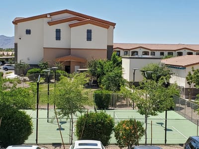 Exterior view of the facility with outdoor space and tennis courts
