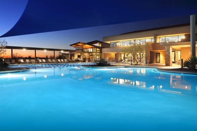 Beautiful outdoor pool area at sunset with the facility in the background