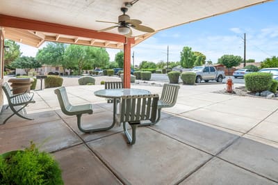 Outdoor seating area with tables and greenery
