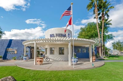 Exterior view of Del Pueblo facility with flags
