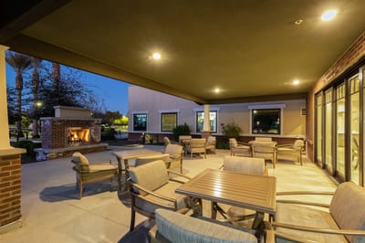 Outdoor seating area with fireplace at dusk