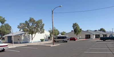 Exterior view of Vianney Villas Apartments with parking lot