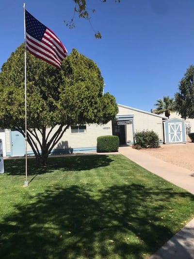 Exterior view of Vianney Villas Apartments with American flag