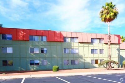 Exterior view of a senior living facility with palm trees