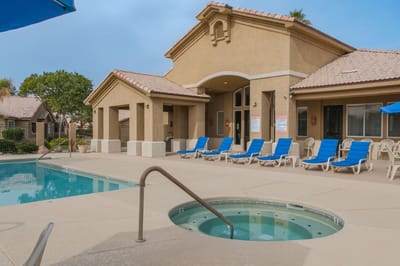 Outdoor pool area with lounge chairs and jacuzzi