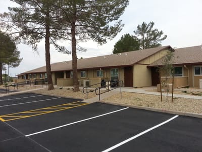 Exterior view of Kachina Apartments with parking and landscaping