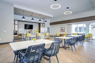 Common area with tables and chairs in a bright room