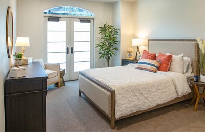 A cozy resident room with a bed and natural light