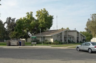 Exterior view of a senior care facility surrounded by trees