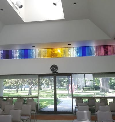 Colorful stained glass in a common area with chairs
