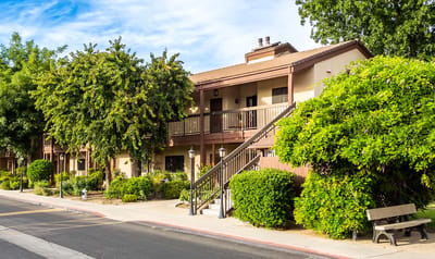 Exterior view of a senior living building surrounded by greenery