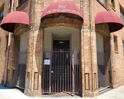 Entrance of Delta Plaza Senior Living with awnings