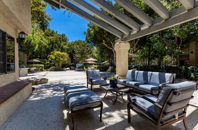 Outdoor seating area with shaded patio and landscaping
