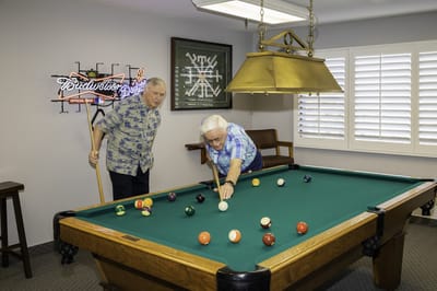 Residents playing pool in an activity room