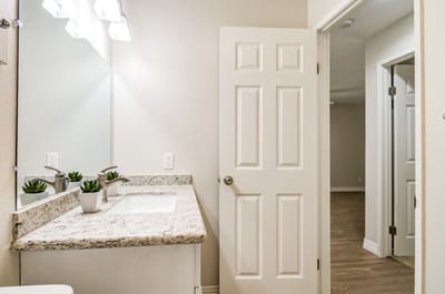 Bright bathroom with granite countertops and mirror