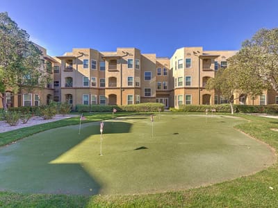 Outdoor putting green with apartment building backdrop