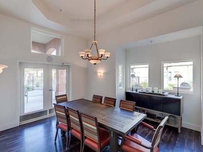 Dining area with a large wooden table and colorful chairs