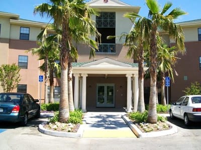 Exterior view of the facility entrance with palm trees