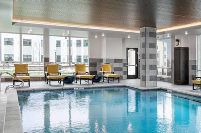 Indoor pool area with yellow lounge chairs