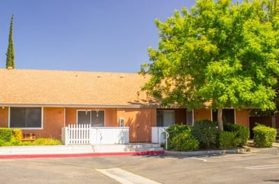 Exterior view of Houser Glen Senior Apartments with trees