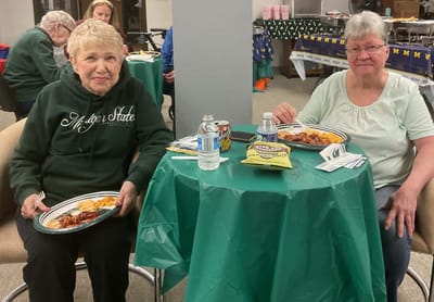 Two residents enjoying meals at a table