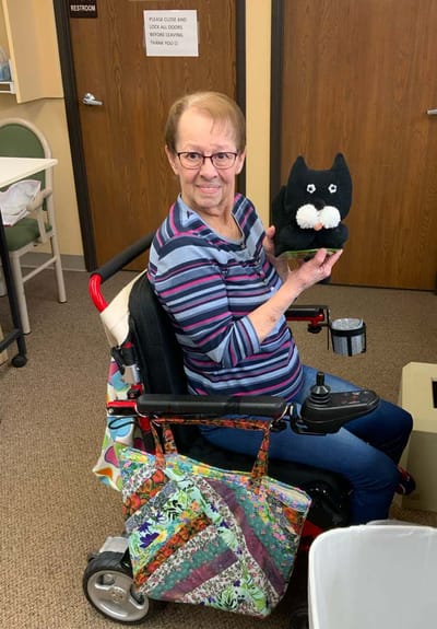 Resident holding a stuffed animal in a facility setting