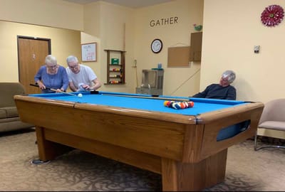 Residents playing billiards in a common area