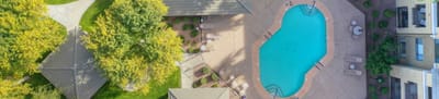 Aerial view of the outdoor pool area surrounded by green spaces