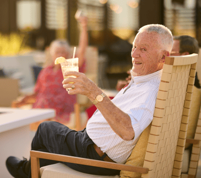 Senior resident enjoying a drink in an outdoor space