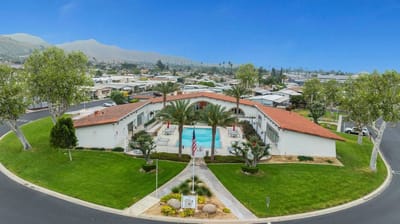 Aerial view of a senior living facility with a pool and landscaped grounds