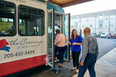 Staff assisting residents boarding a facility shuttle