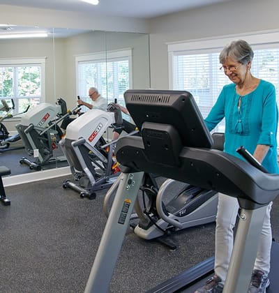 Resident using exercise equipment in a gym