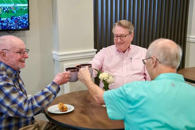 Three residents enjoying coffee together in a common area