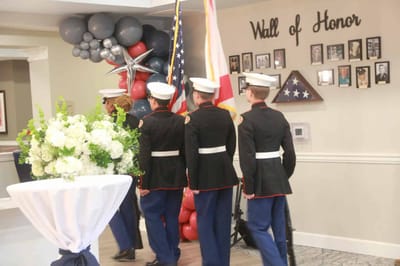 Residents and military personnel honoring veterans at an event