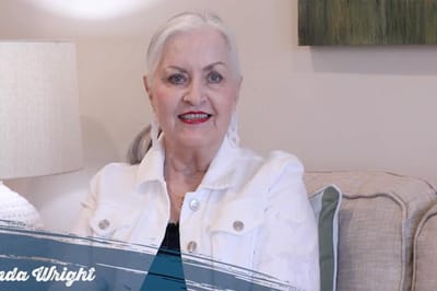 Senior resident posing for a photo in a cozy living room