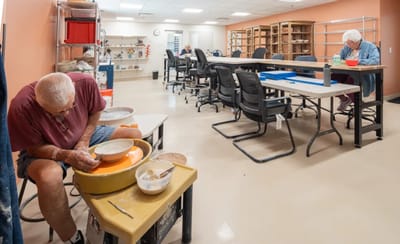 Residents engaging in pottery in a crafting room