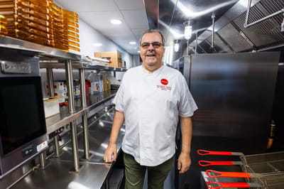 A chef standing in a spacious kitchen