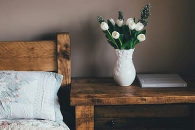 Cozy bedside table with flowers and a book