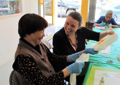 Residents engaged in an art activity with a staff member