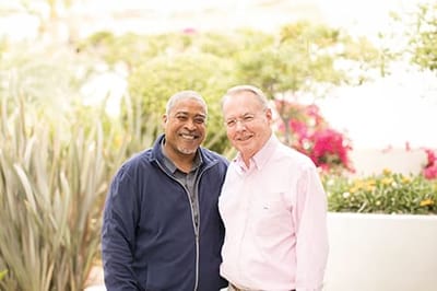 Two smiling residents in a garden setting