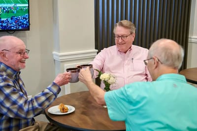 Three residents enjoying coffee together in a common area